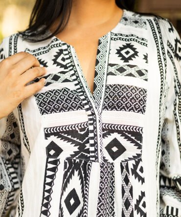 Zoomed-in view of printed cotton dobby dress highlighting ruffle sleeves and fine dobby weave texture.