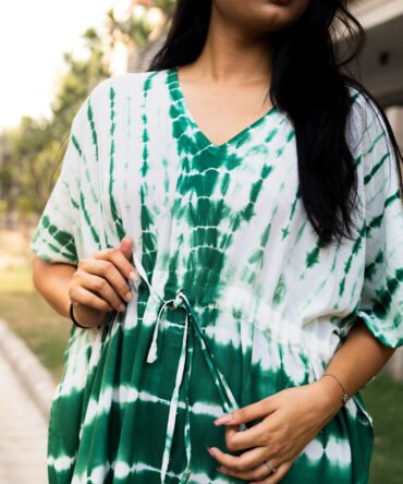 Close-up of model wearing a green and white tie-dye kaftan dress with V-neck and adjustable drawstring waist