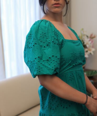 Close-up of green cotton eyelet maxi dress showing square neckline, puff sleeves, and detailed embroidery