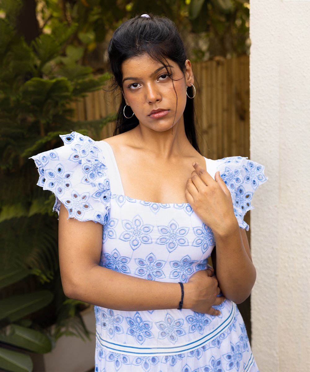 Close-up of Blue and White Cotton Eyelet Tiered Dress showing embroidered floral pattern and fabric texture