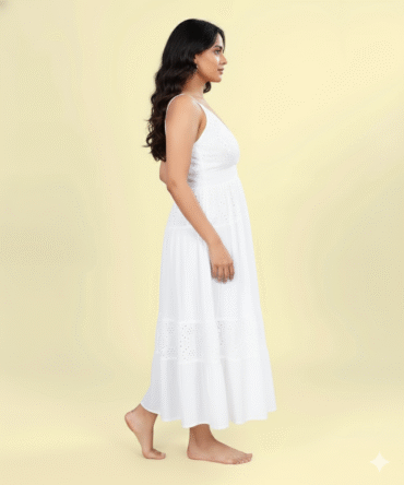 Side view of white cotton eyelet sleeveless maxi dress featuring V-neckline and tiered design.