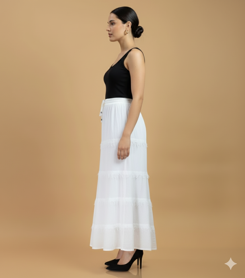 Side view of white cotton fringe tier maxi skirt showing flowy silhouette and textured fringe detailing