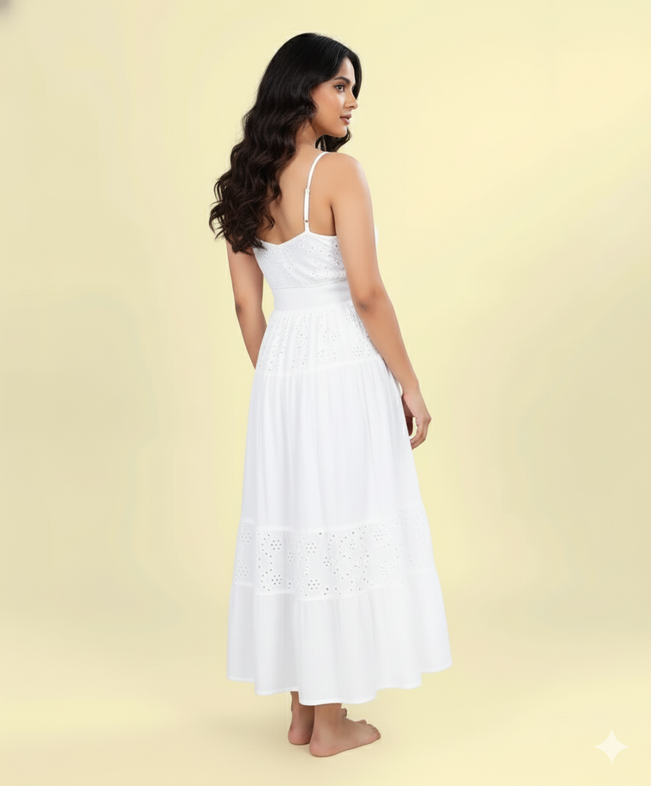 Back view of white sleeveless cotton eyelet maxi dress with tiered hem and smocked back.