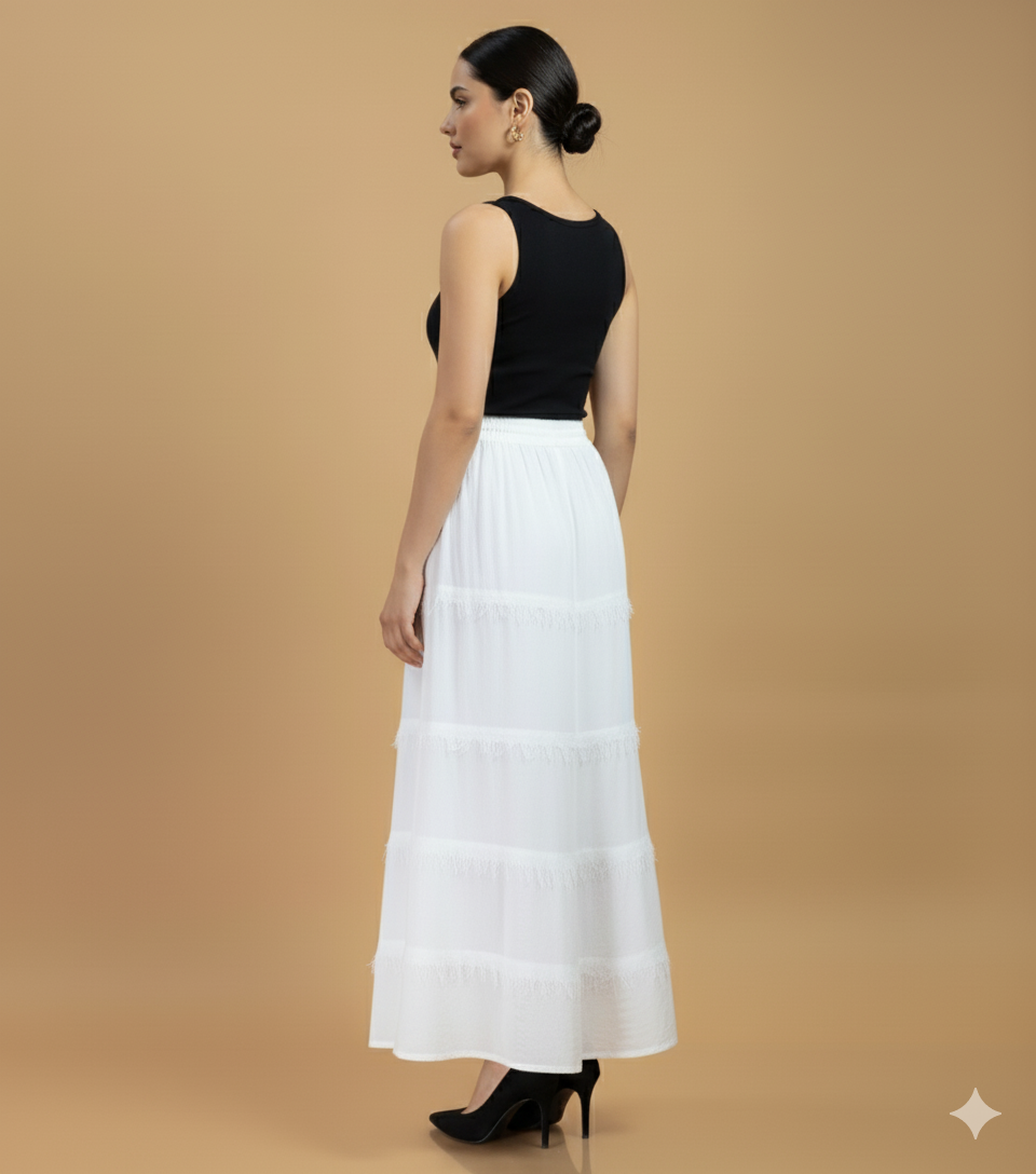 Back view of white cotton fringe tier maxi skirt with elasticated waistband and layered fringe tiers