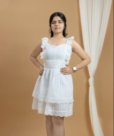 Front view of white cotton eyelet dress with scalloped lace detailing and ruffled straps