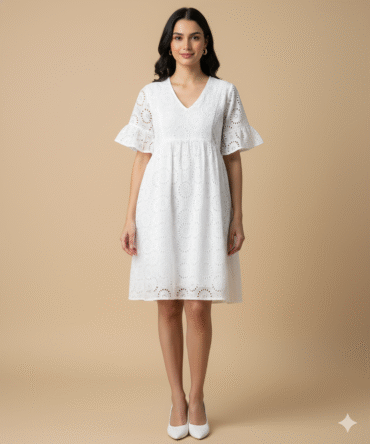 Model wearing white cotton eyelet V-neck dress with ruffle sleeves, front view