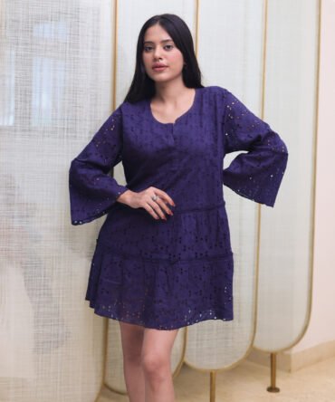 Front view of navy blue cotton eyelet dress with flared sleeves and tiered hem