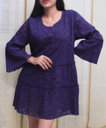 Close-up of navy blue cotton eyelet dress showing embroidery detail and soft fabric texture