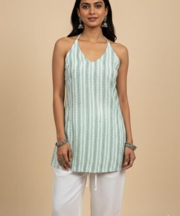 Model wearing green printed halter cotton kurti with tie-back design and white pants – boho chic summer outfit.