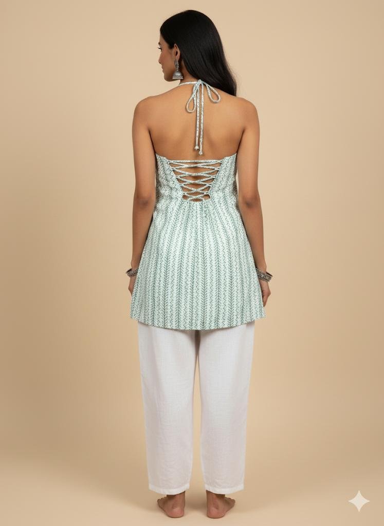 back pose of Model wearing green halter neck corset kurti with corset tie-back and halter straps, styled with white cotton pants — boho chic minimal summer outfit