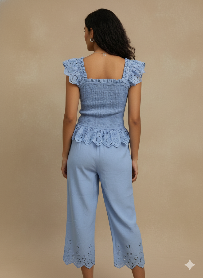 back view of sky blue cotton eyelet co-ord set with ruffle sleeves and scalloped hem pants — minimal summer outfit, cottagecore Pinterest vibe, chic resort wea