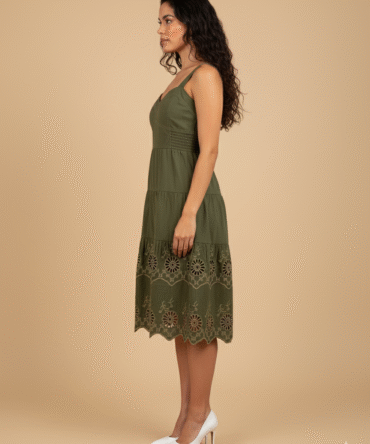 Side view of olive green cotton midi dress featuring tan eyelet embroidery and tiered detailing.