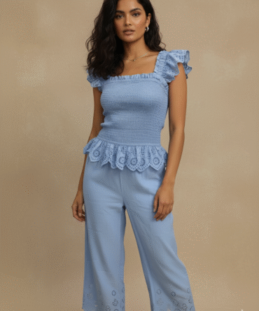 front pose of model wearing sky blue cotton eyelet co-ord set with ruffle sleeves and scalloped hem pants — minimal summer outfit, cottagecore Pinterest vibe, chic resort wear