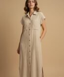 Woman wearing a biege cotton double gauze button-down dress styled for fall fashion, featuring short sleeves and a relaxed neutral chic look.