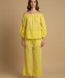 Model wearing a yellow cotton off shoulder co-ord set, with eyelet detailing