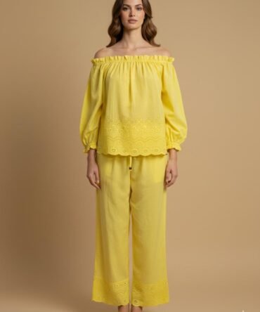 Model wearing a yellow cotton off shoulder co-ord set, with eyelet detailing