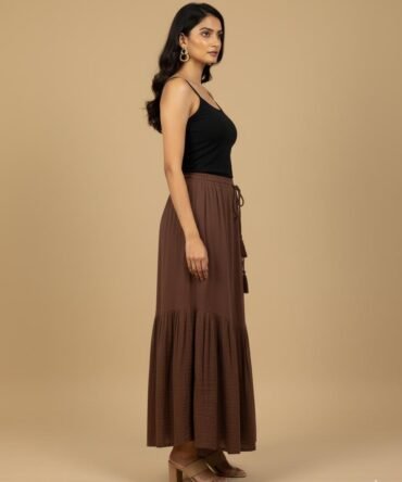 Model in side view wearing a brown maxi skirt styled with a black cami top.